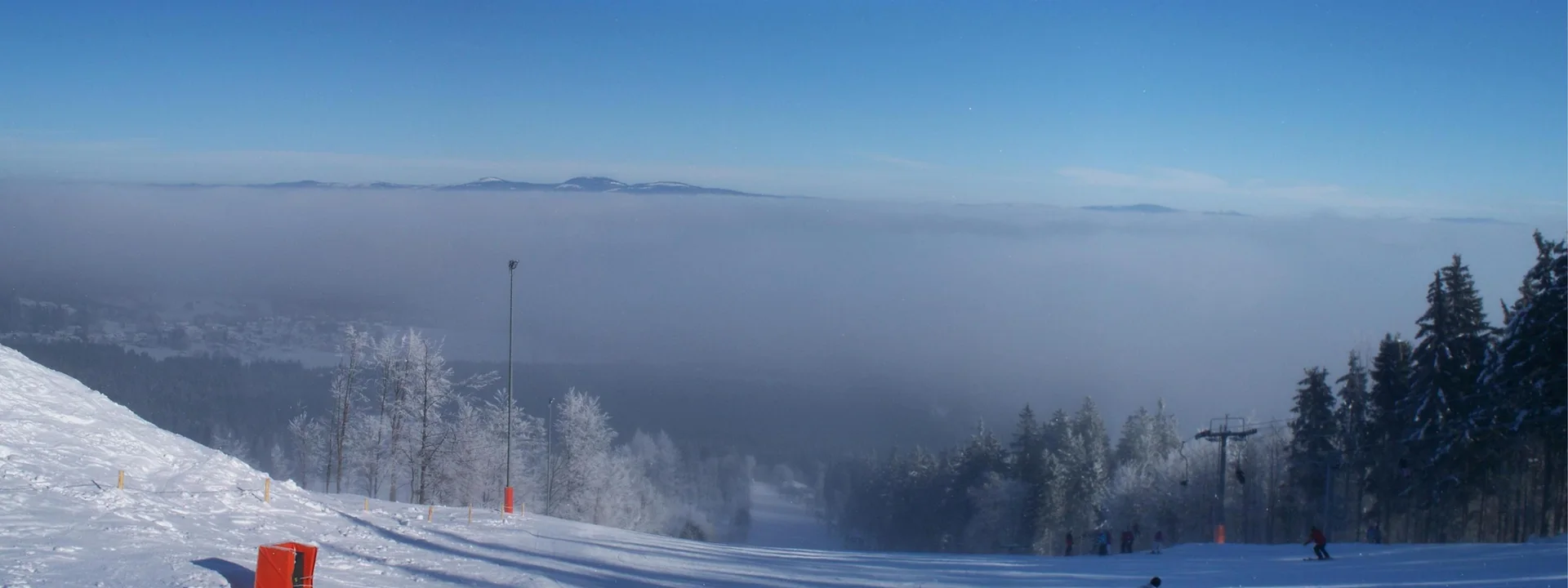 Verschneite Piste am Geißkopf bei Bischofsmais mit Blick über das Nebelmeer